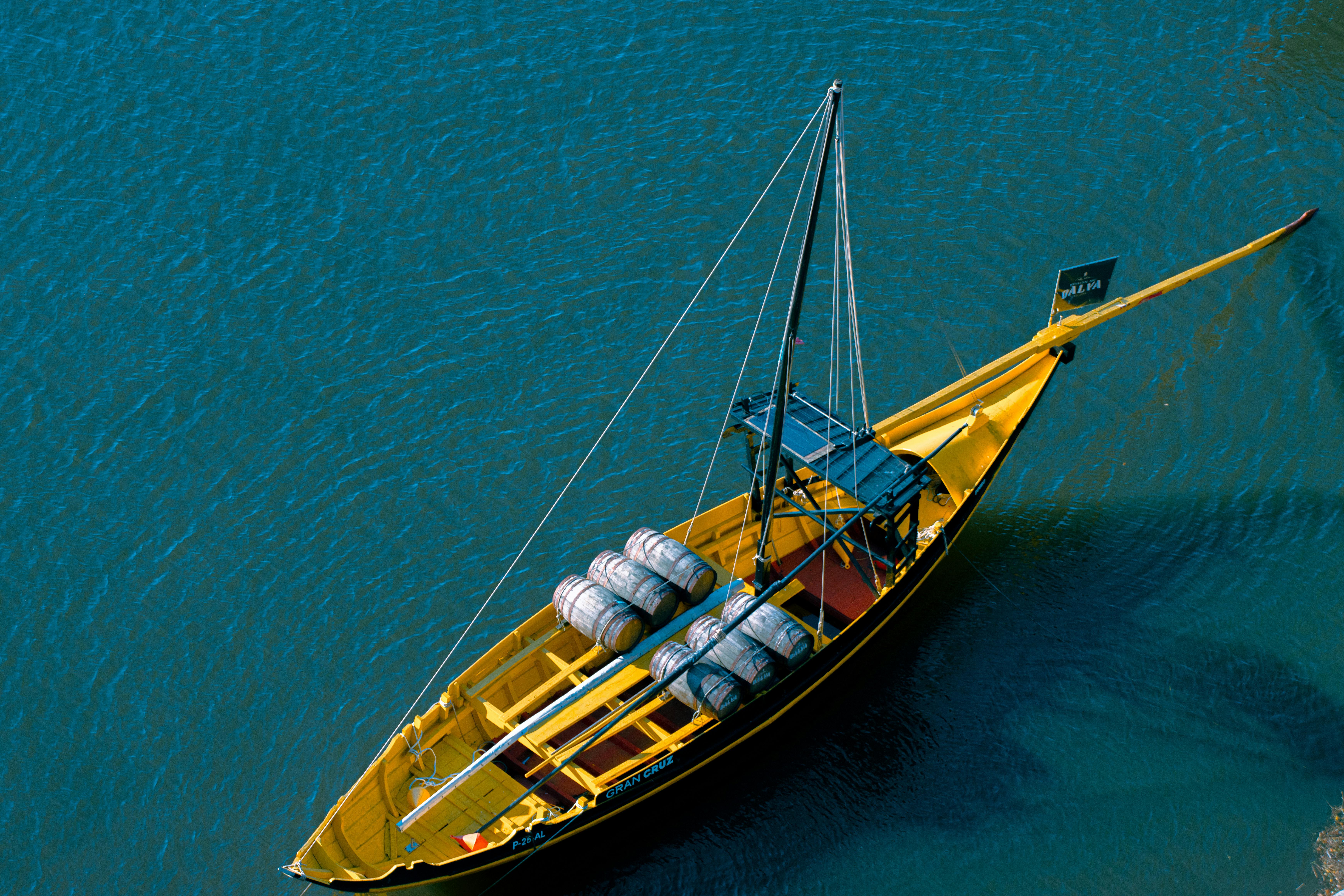 A traditional Rabelo boat with barrels gliding on the Douro River in Porto, Portugal.