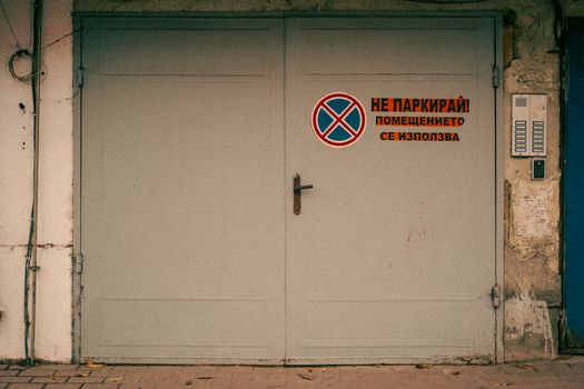 A vintage garage door in Varna, Bulgaria, displaying a 'No Parking' sign in Bulgarian language.