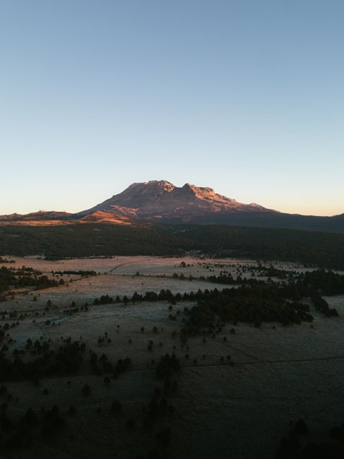 A stunning aerial view of Iztaccihuatl Volcano in Mexico at sunrise, showcasing the majestic landscape.