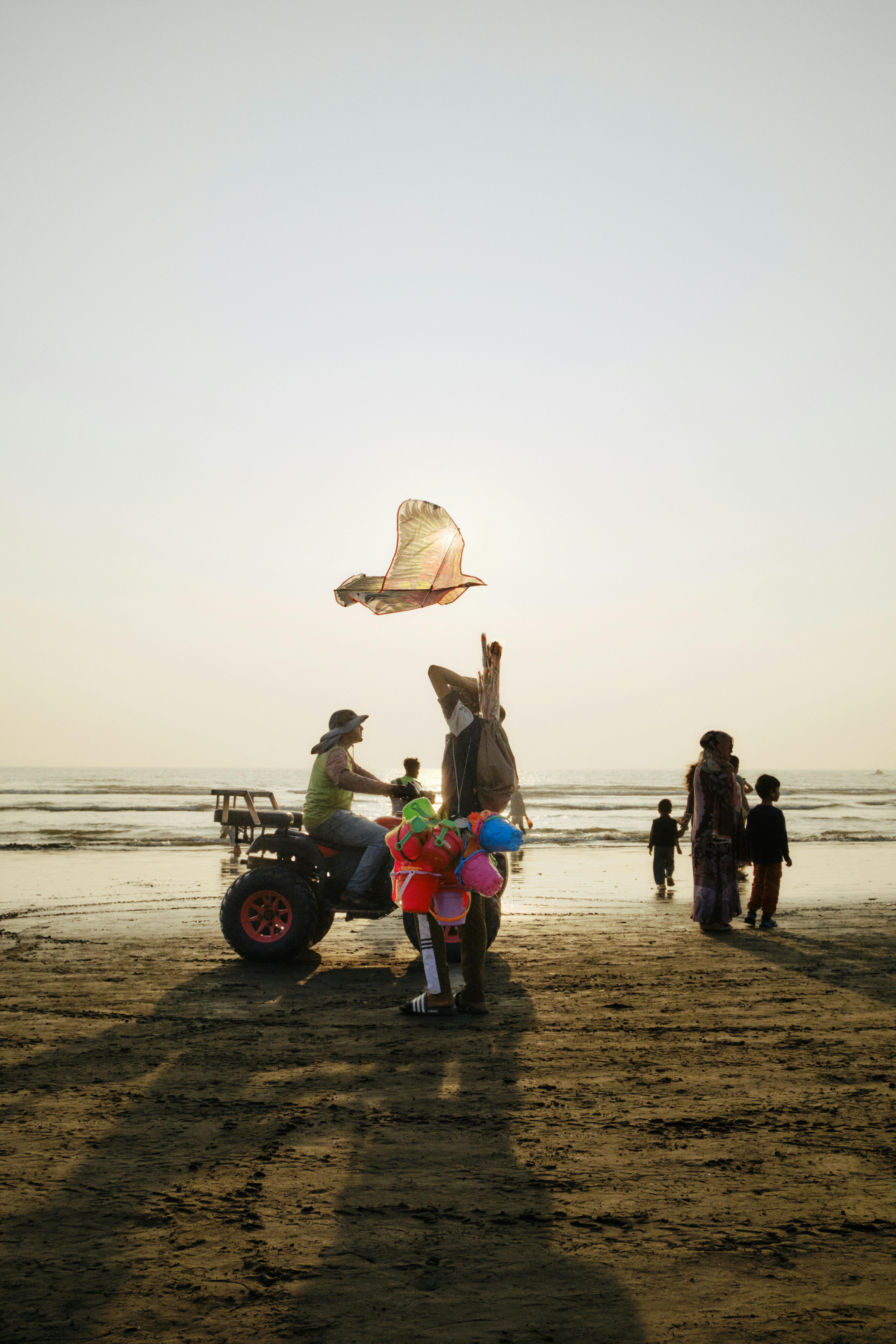 People enjoying kite flying at sunset on Cox's Bazar Beach, Bangladesh.