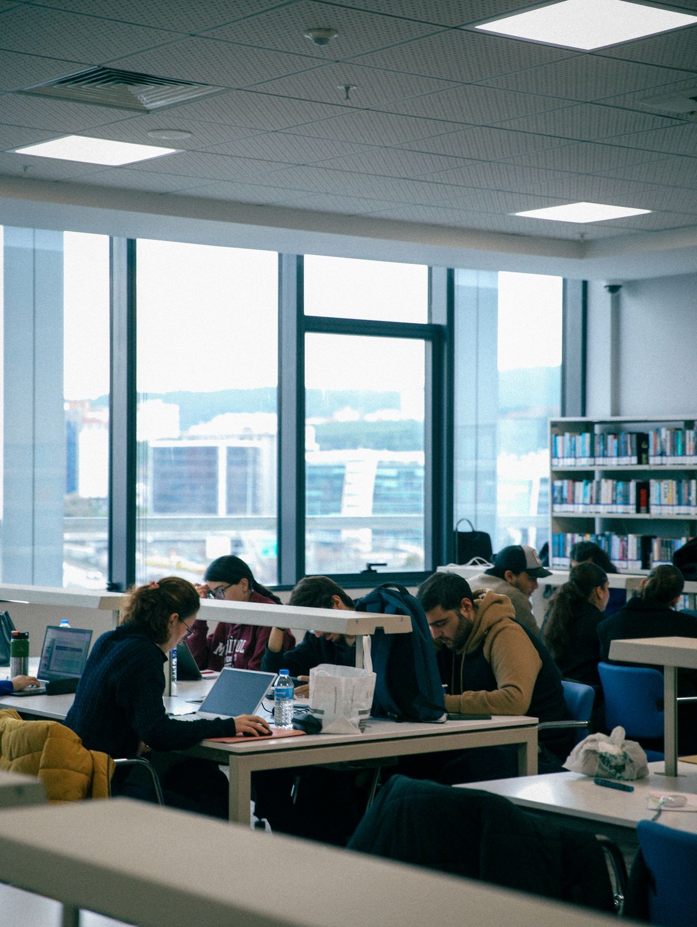 Groupe de personnes qui étudient dans une bibliothèque moderne et lumineuse