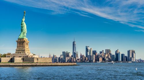 Free Breathtaking view of the Statue of Liberty with the Manhattan skyline in the background. Stock Photo