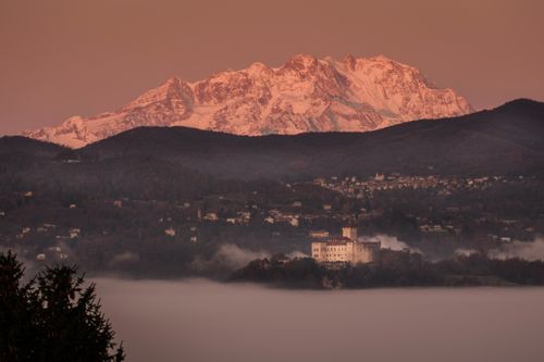 Free A breathtaking view of snow-capped mountains and a misty valley at sunrise, highlighting serene natural beauty. Stock Photo