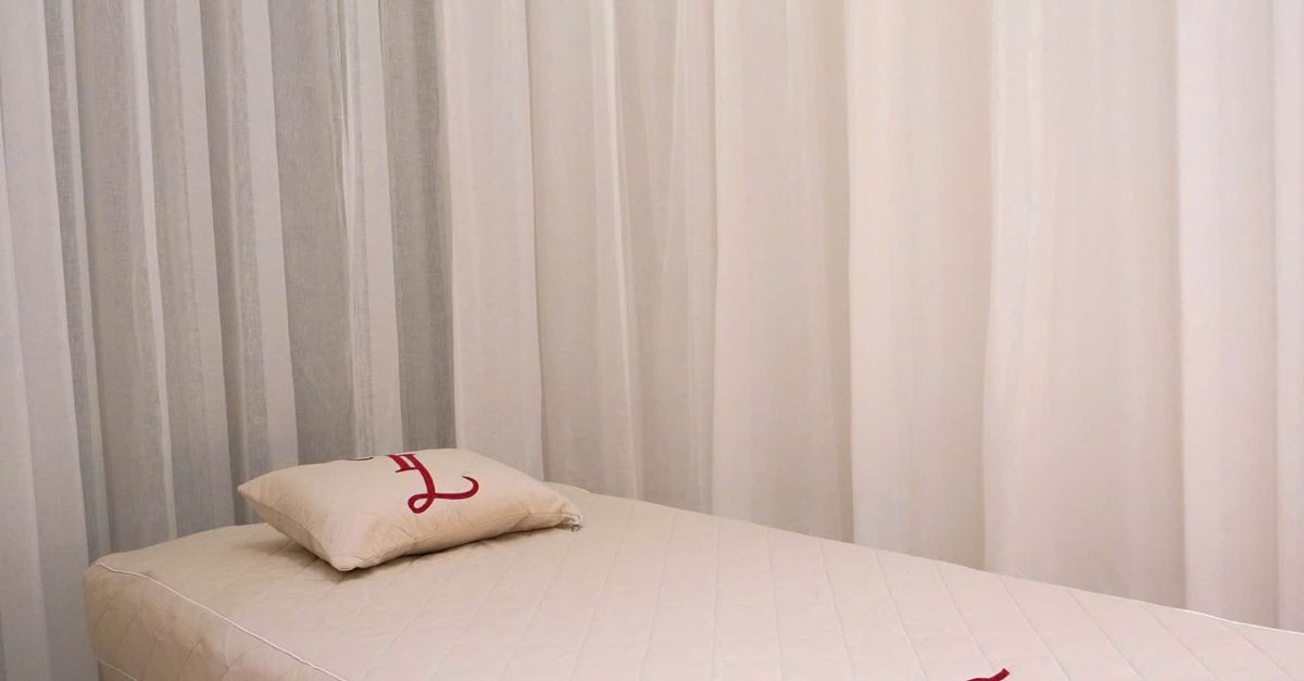 A calm spa setting showcasing a massage table with white drapes.