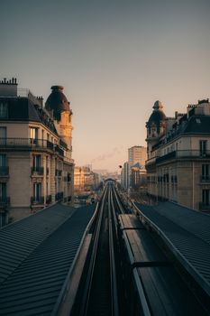 Captivating view of Parisian architecture and railway from above during sunset.