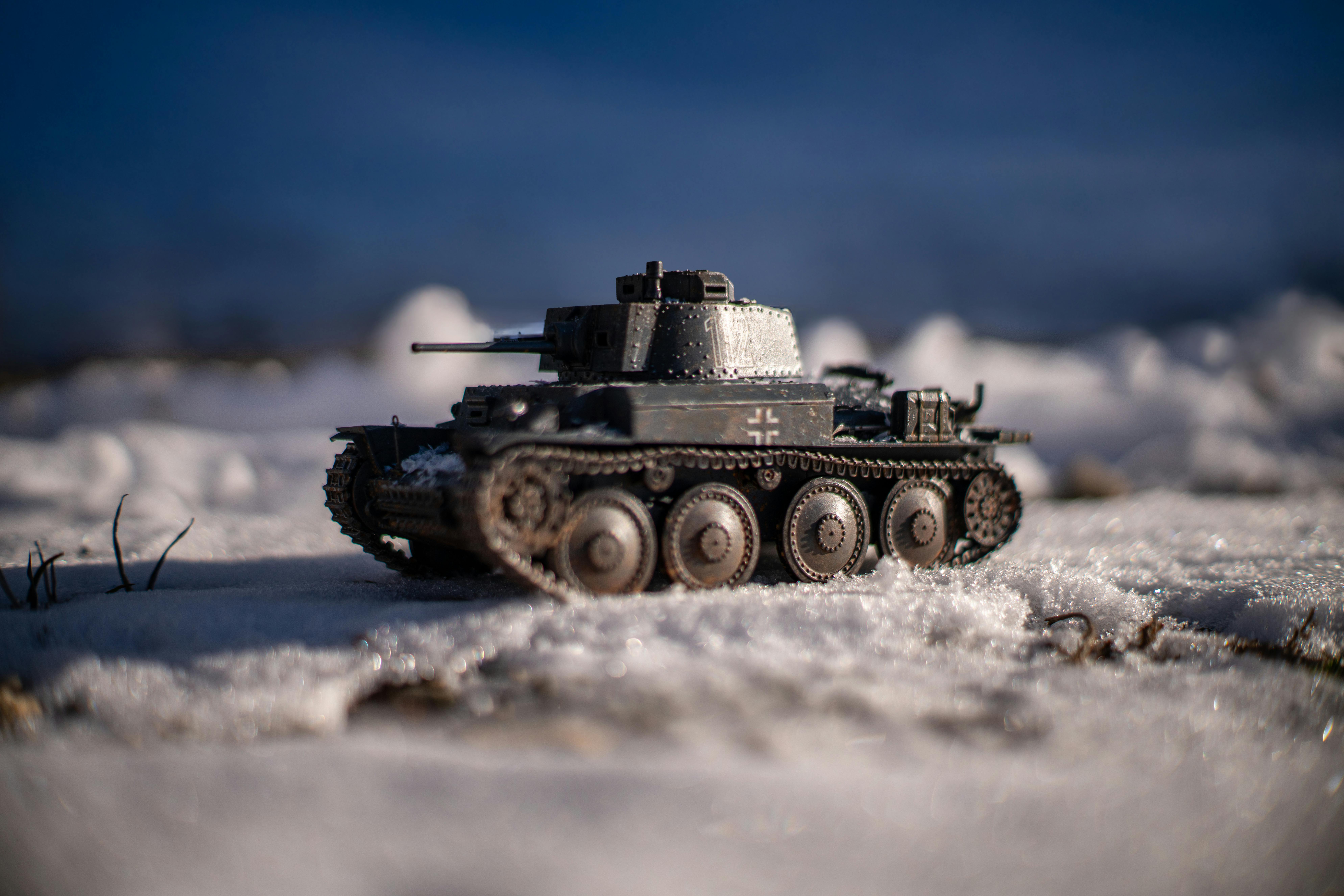 bezplatná Detailní záběr na detailní model tanku v měřítku na zasněženém terénu za jasné oblohy. Základová fotografie
