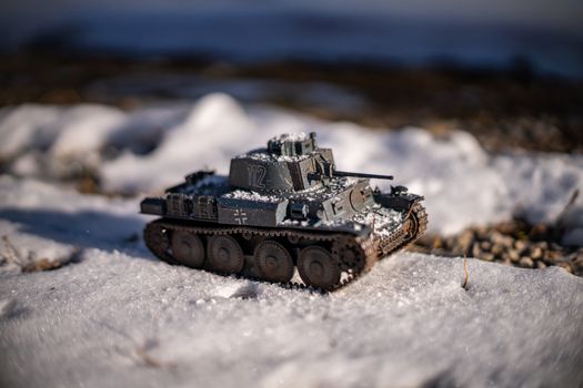 Close-up of a detailed model tank set against a snowy landscape, capturing a winter-themed miniature scene.