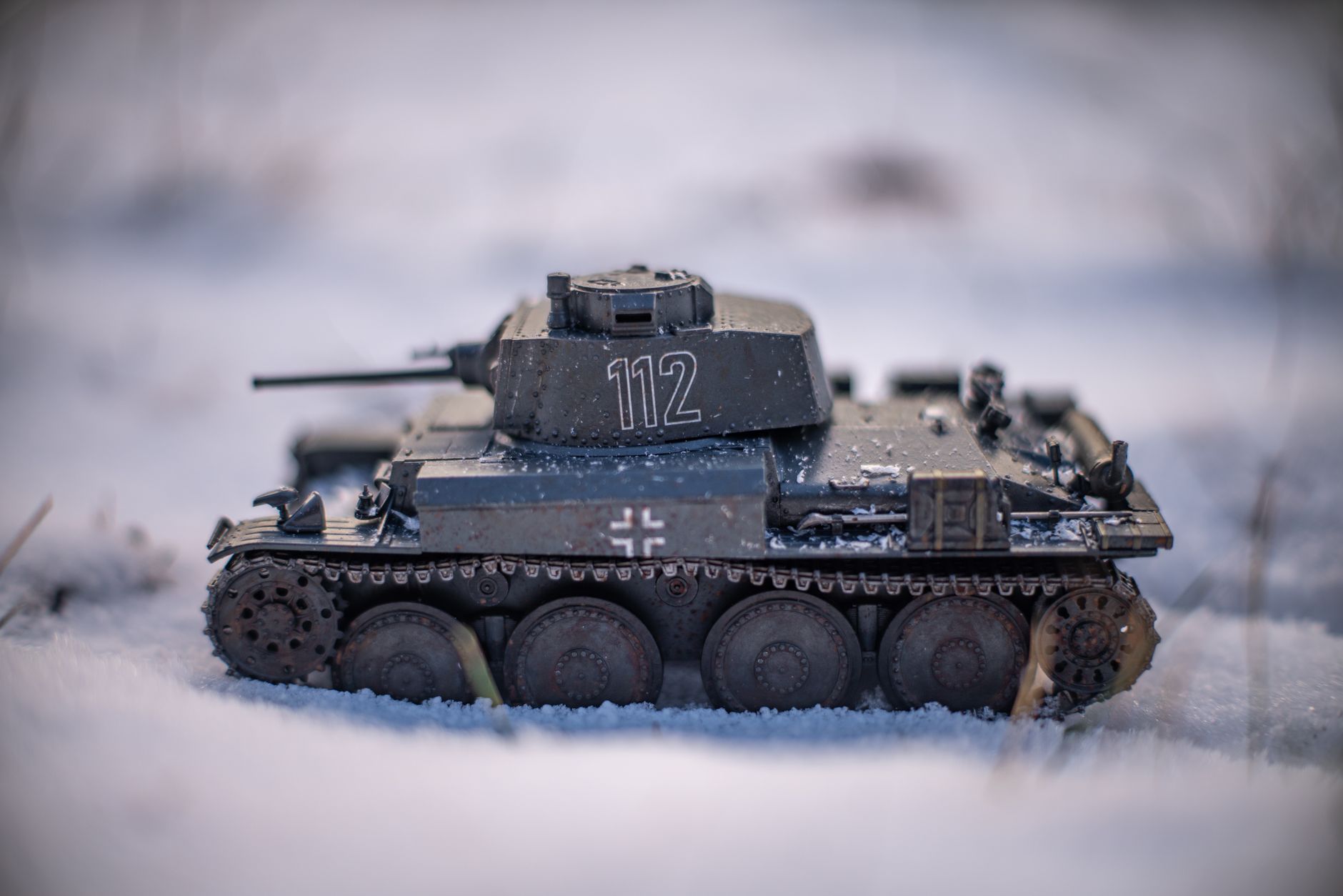 Close-up of a detailed WWII tank scale model in a snowy outdoor setting.