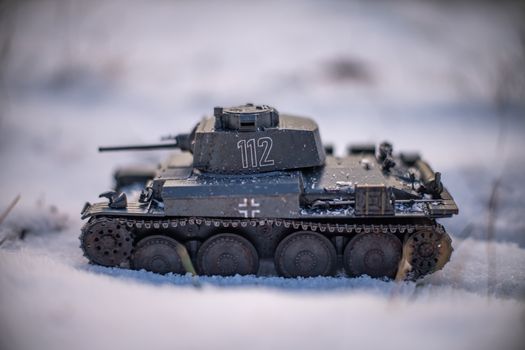 Close-up of a detailed WWII tank scale model in a snowy outdoor setting.
