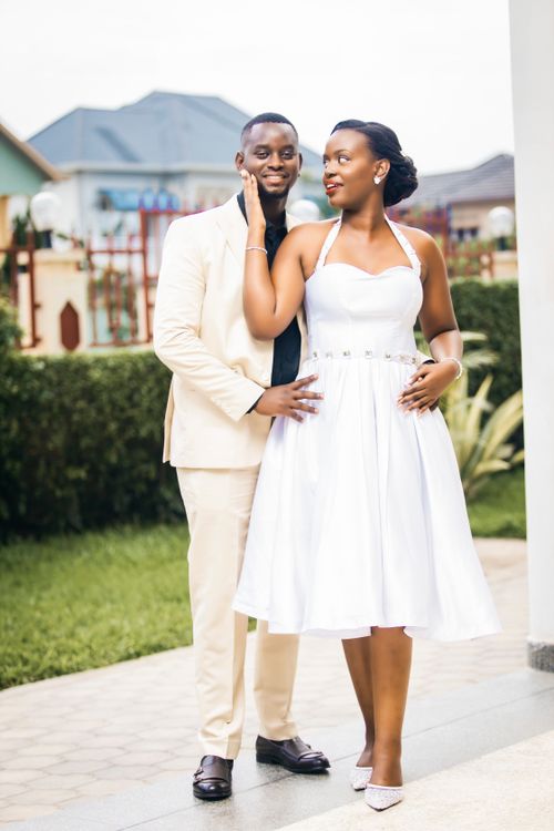Free Portrait of a smiling couple in elegant outfits with a garden backdrop. Stock Photo