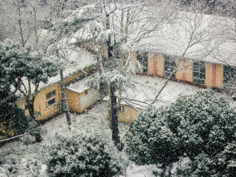 A quiet suburban house blanketed in snow, creating a serene winter landscape.