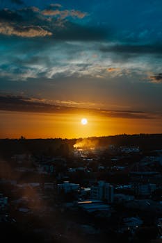 A vibrant sunset casting warm colors over a city skyline, creating a dramatic and beautiful scene.