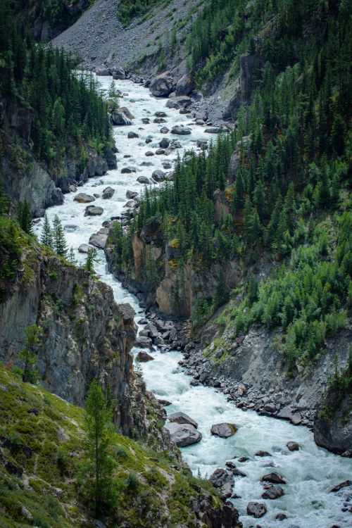 Free A picturesque river winds through a lush green mountain valley, showcasing nature's beauty. Stock Photo
