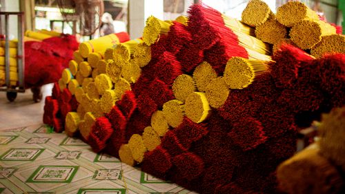 Free Vibrant red and yellow incense sticks stacked in a traditional workshop in Ho Chi Minh City, Vietnam. Stock Photo