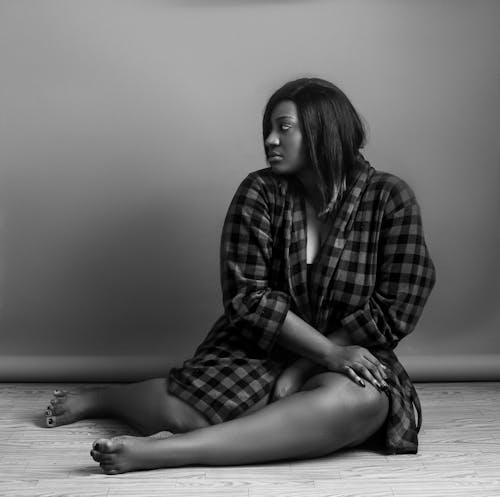 Grayscale Photo of Woman Sitting on Floor