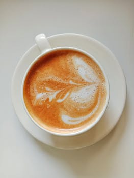 Top view of a beautifully crafted coffee latte with artistic foam design, perfect for coffee lovers.