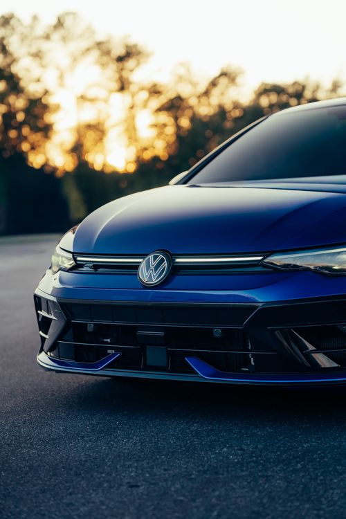 Free Close-up of a blue car's front, set against a stunning sunset backdrop. Stock Photo