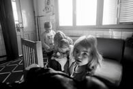 A candid black and white photo of children interacting indoors, creates a classic moment.