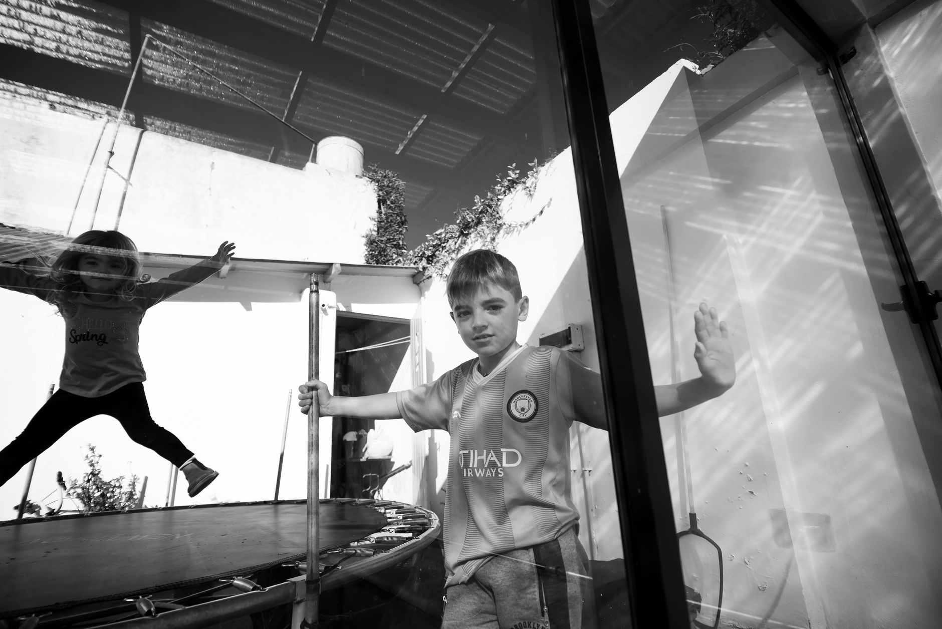 trampoline rental for parties egypt — Children playing on a trampoline indoors in black and white setting.