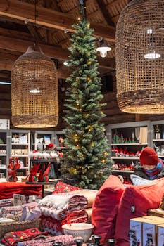 Warm interior of a boutique with festive decorations, a tall Christmas tree, and holiday merchandise.