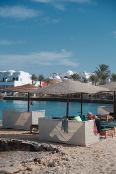 Coastal scene featuring straw umbrellas and a serene resort backdrop, perfect for a summer getaway.