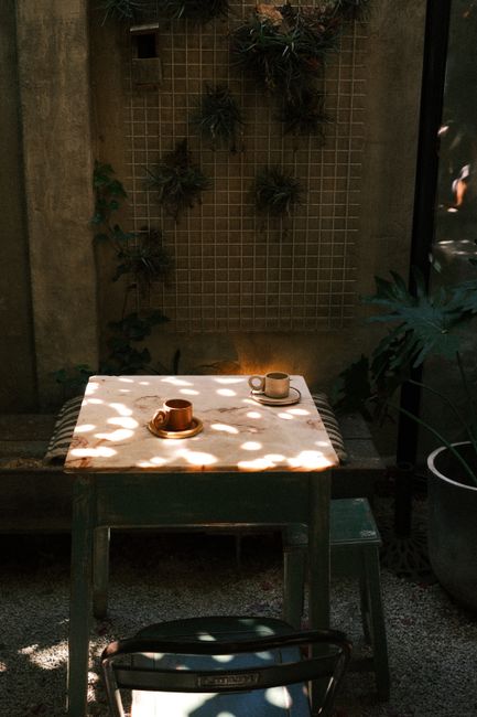 Sunlit outdoor café table with coffee cups in Lisbon, Portugal.