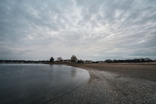 Serene coastal view with empty beach under cloudy skies, capturing tranquility.