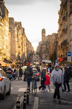 A busy winter street in Paris with people crossing and classic architecture in view.