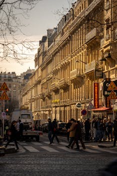 A moody Parisian street scene with classic architecture and pedestrians in winter.
