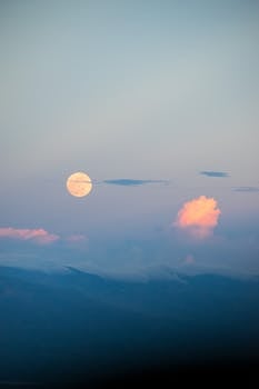 A serene full moon shines over the cloud-kissed mountains of Tehuacán, Mexico.