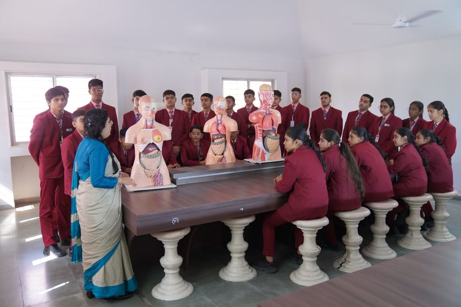 Students examining anatomical models during a biology class in Petlad, Gujarat