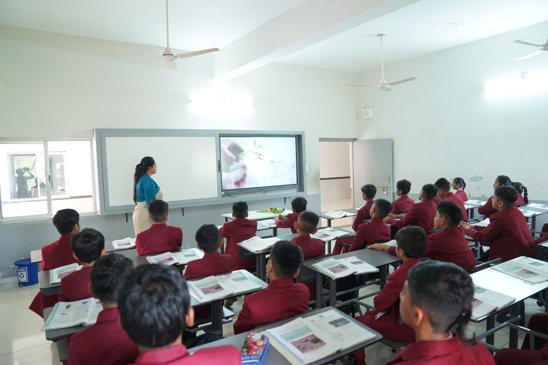 Students learning in a modern classroom with an interactive display