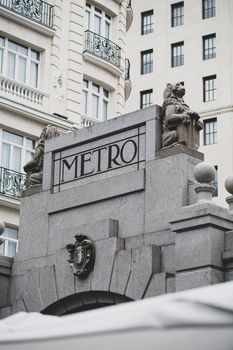A classic architectural entrance to the metro in central Madrid, Spain with intricate statues and design.