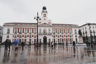 A bustling city scene in Puerta del Sol, Madrid, with pedestrians and historic architecture.