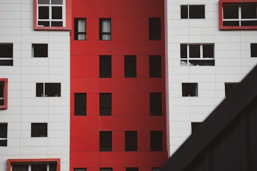 Close-up of a striking red and white building facade with geometric window patterns.