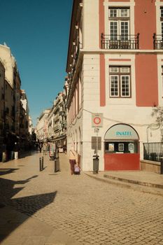 Idyllic view of a sunlit street in Lisbon, showcasing traditional architecture and vibrant life.