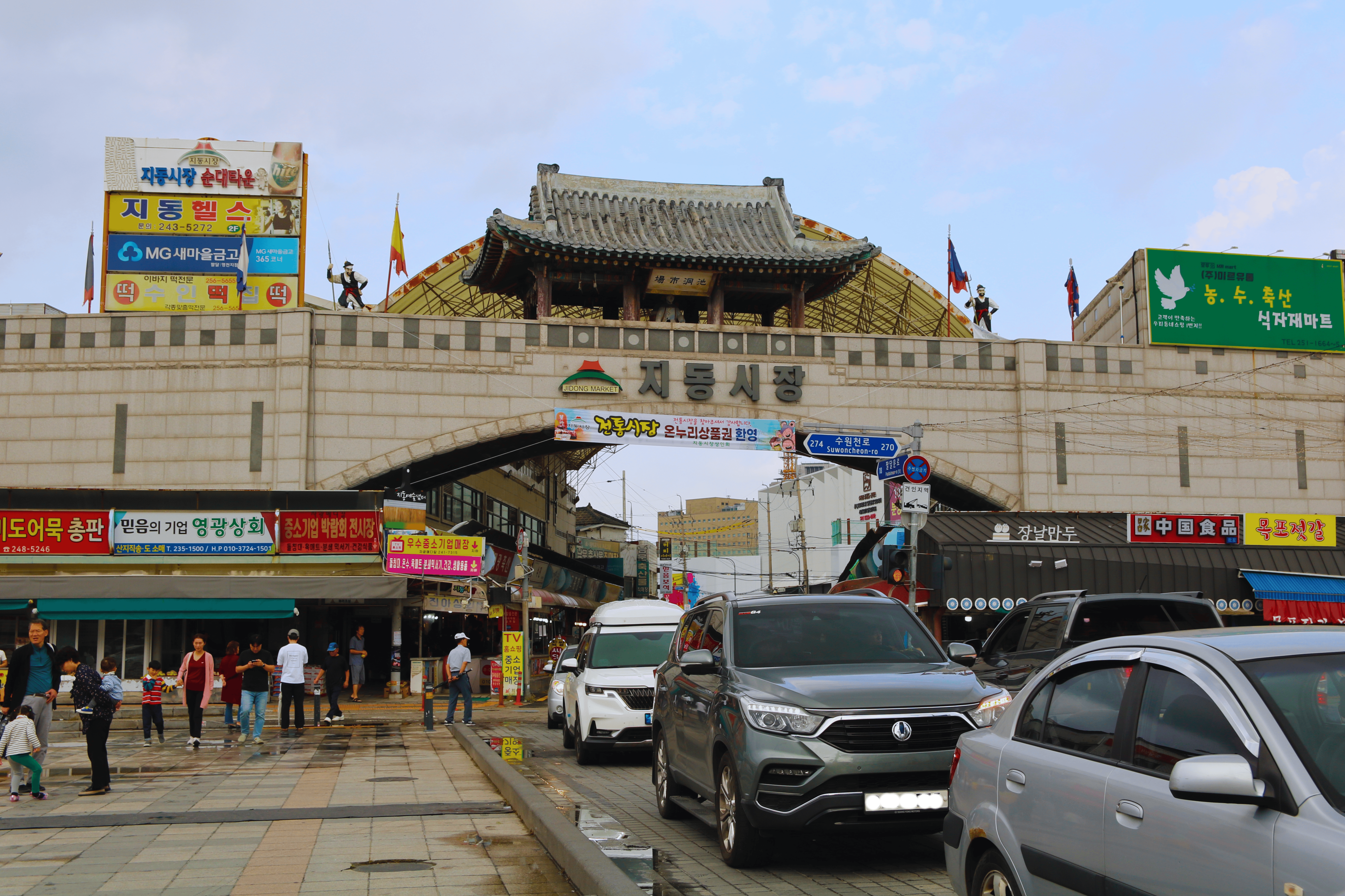 View of Jidong Market entrance in Suwon, South Korea, showcasing traditional architecture and local street life.
