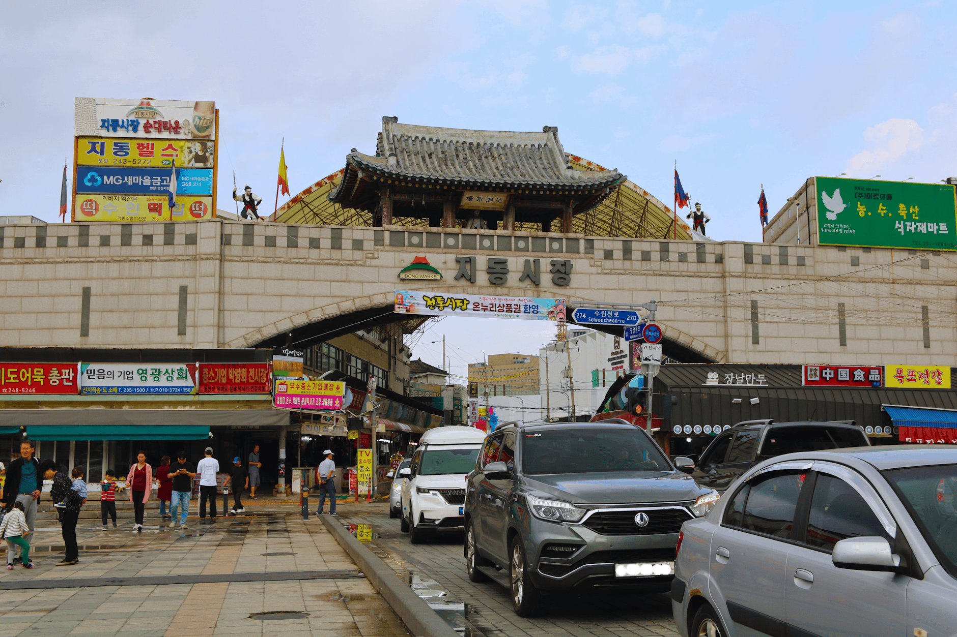 View of Jidong Market entrance in Suwon, South Korea, showcasing traditional architecture and local street life.