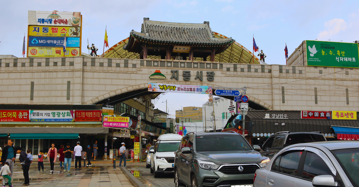 View of Jidong Market entrance in Suwon, South Korea, showcasing traditional architecture and local street life. visual (Photo: Bruna Santos / Pexels)
