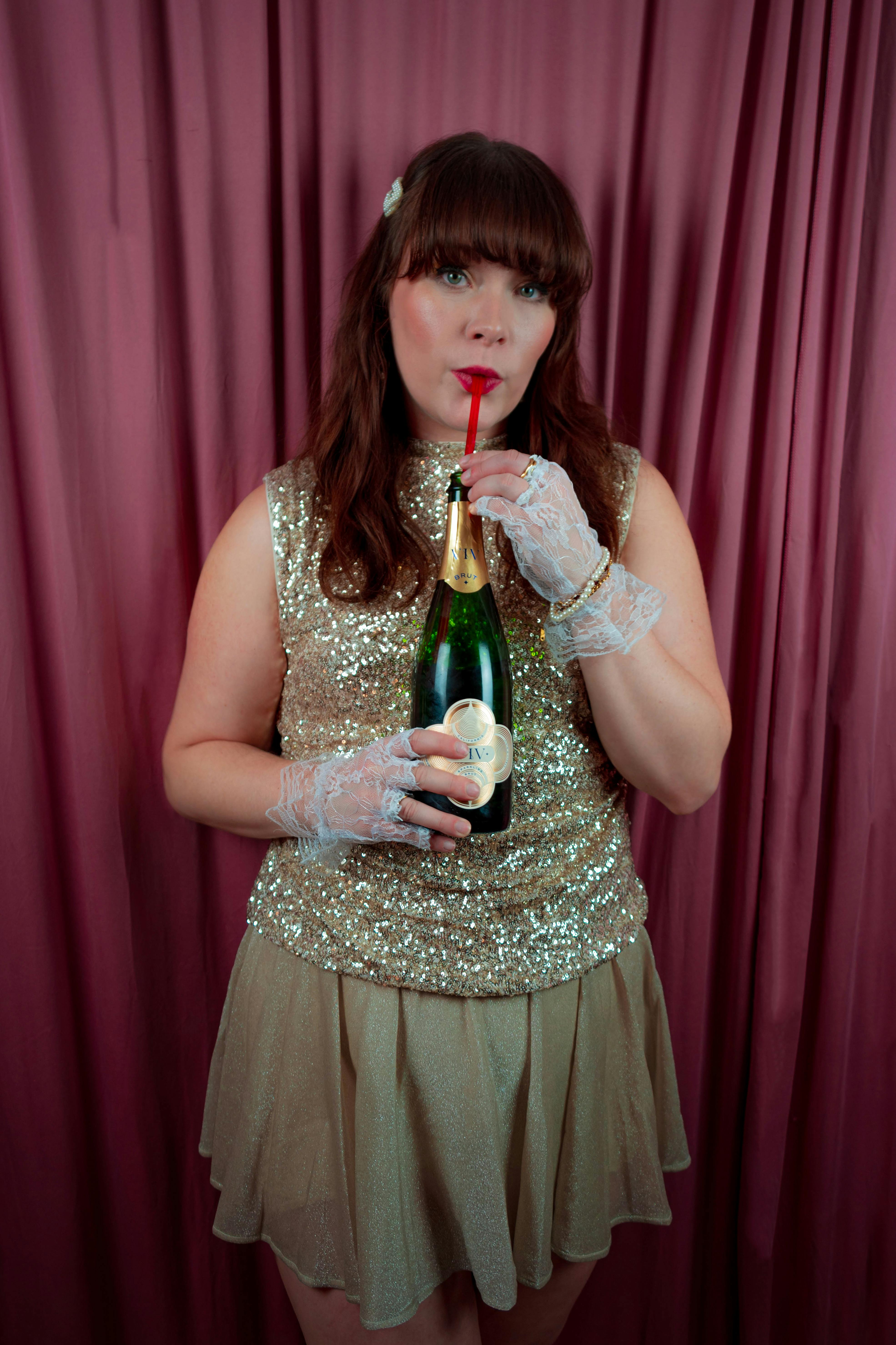 Gratuit Une femme élégante en robe à paillettes savoure du champagne, incarnant la fête. Photos