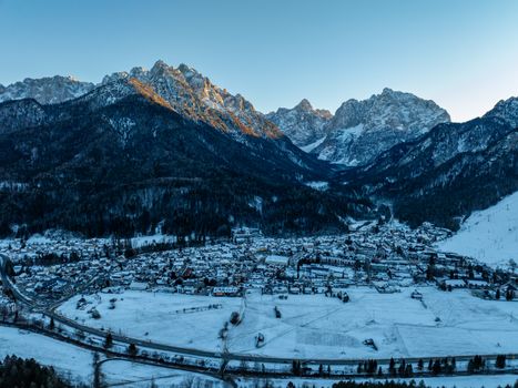 A stunning aerial view of Kranjska Gora, Slovenia, blanketed in snow with mountain backdrop.