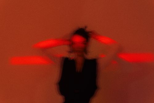 Free Abstract blurred portrait with striking red lighting creating a dynamic and mysterious atmosphere. Stock Photo