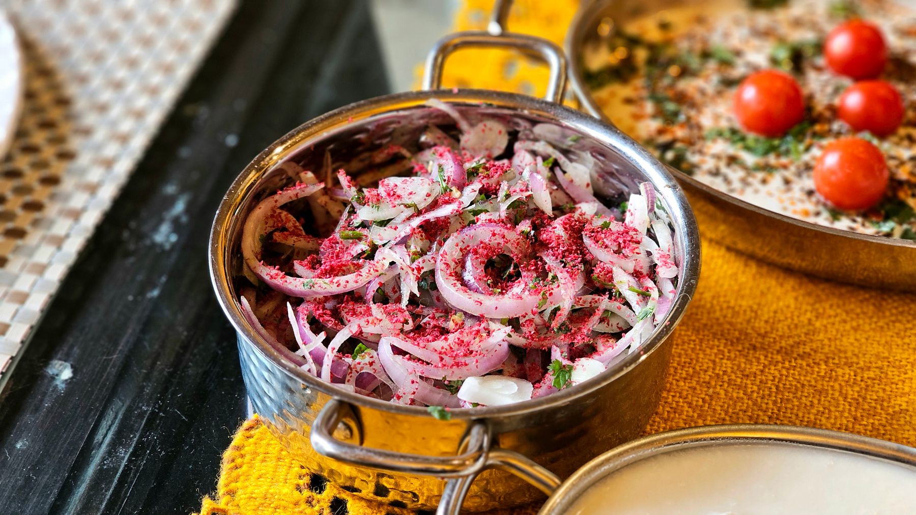 Fresh onion salad garnished with sumac and herbs