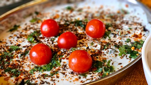 Free A vibrant yogurt dish topped with cherry tomatoes, herbs, and spices, perfect for culinary inspiration. Stock Photo