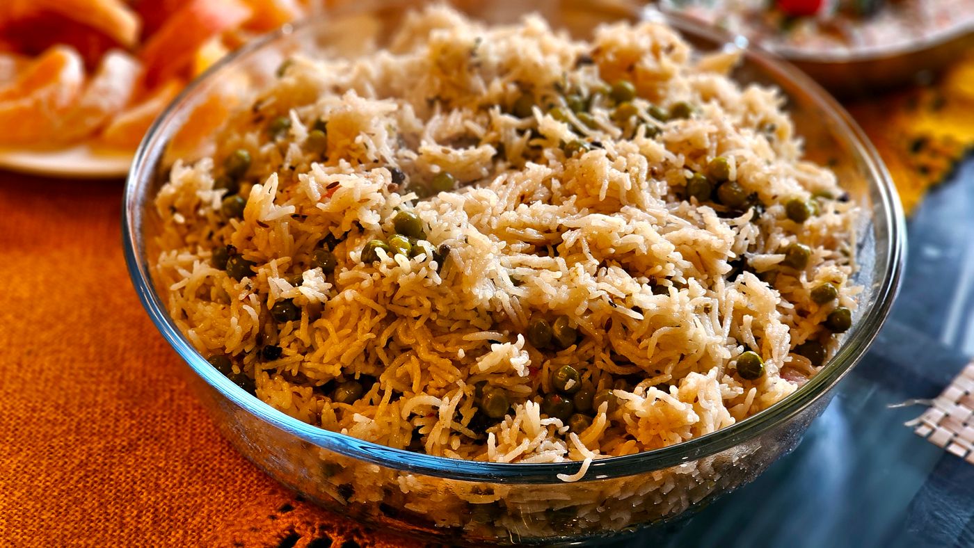 Mouthwatering pea pulao served hot in a transparent glass bowl, perfect for any meal.