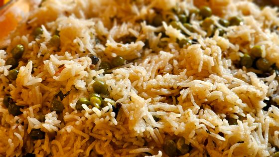 Close view of fluffy basmati pulao studded with green peas and cumin seeds