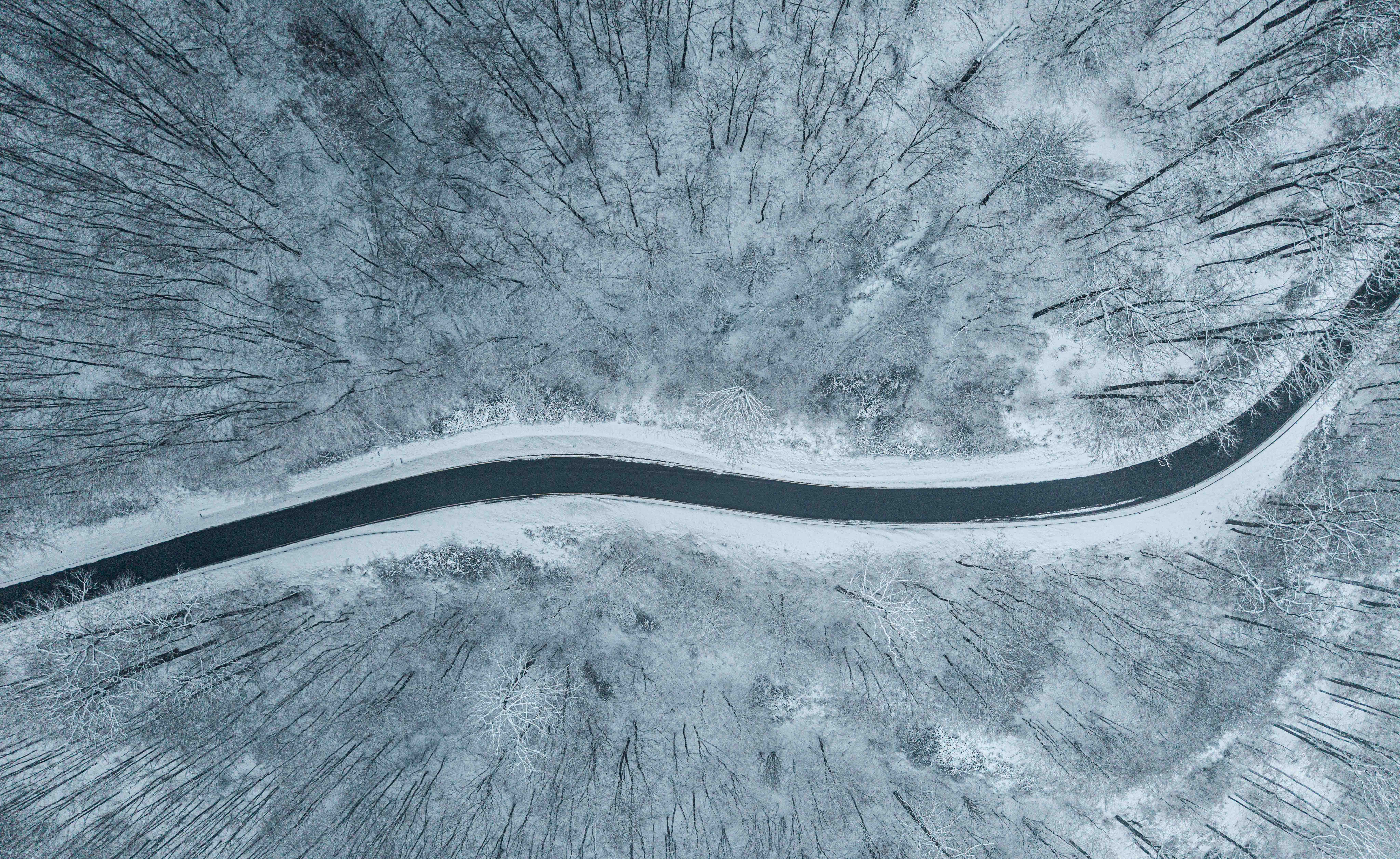 Aerial View of Snow-Covered Winter Forest Road · Free Stock Photo