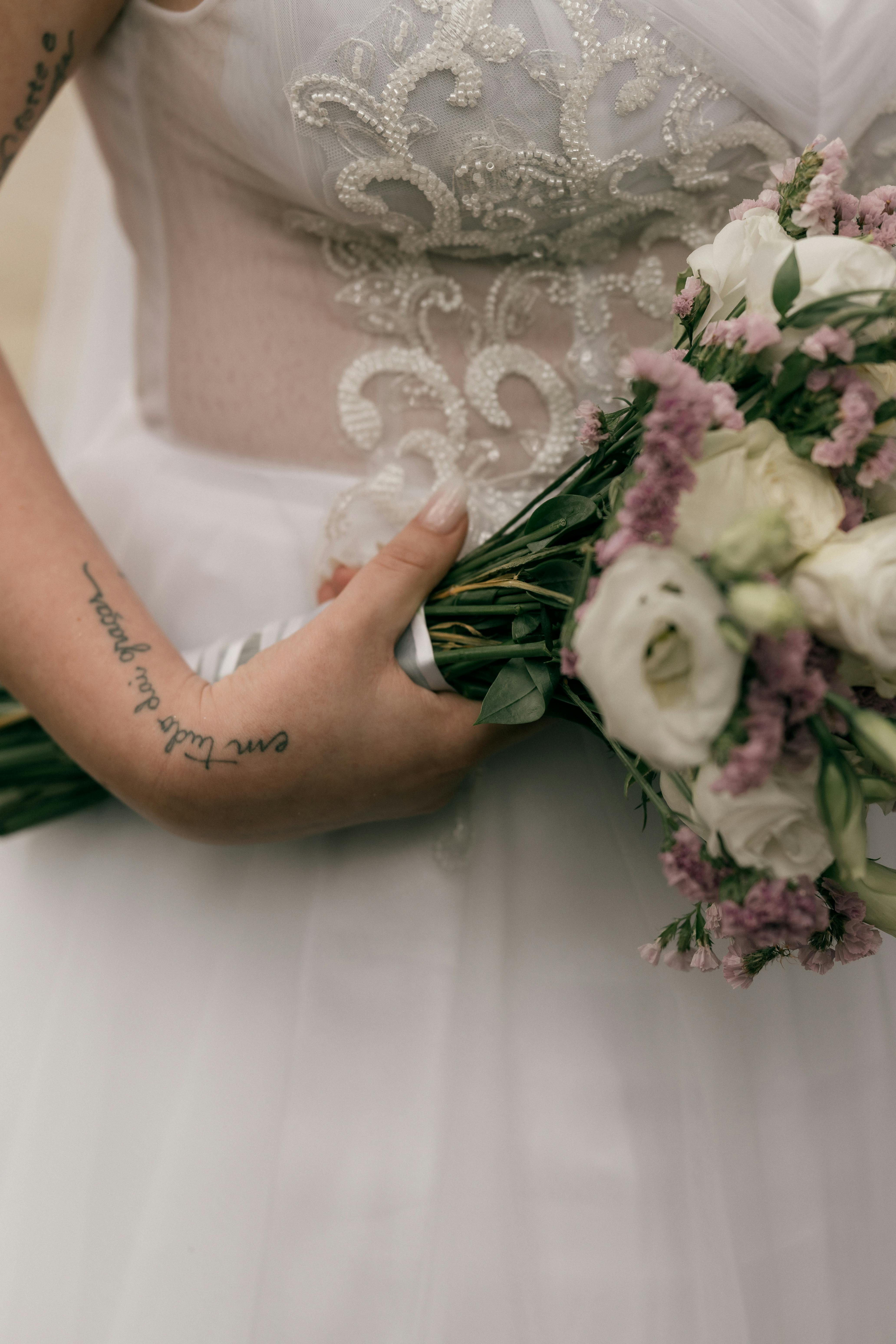 Gratuit Gros plan sur une mariée avec un bouquet de fleurs composé de roses blanches et de lavande. Photos