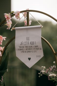 Elegant wedding arch with floral decorations and a text banner, symbolizing love and faith.