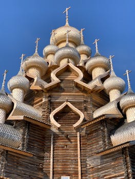 Close-up of the Kizhi Pogost wooden church domes under a clear blue sky.